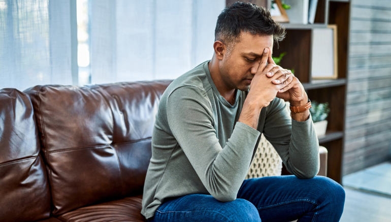 worried man sits on couch