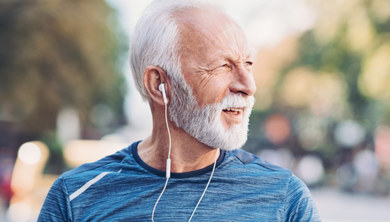 older man walking holding watch