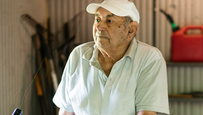 Old man standing in shed