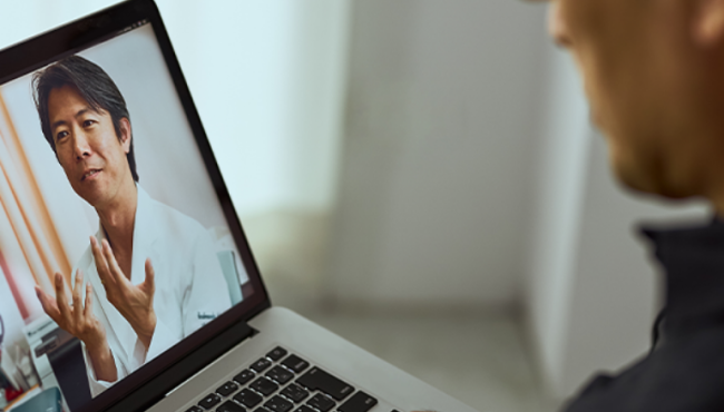 Older man attending a virtual GP appointment on his laptop