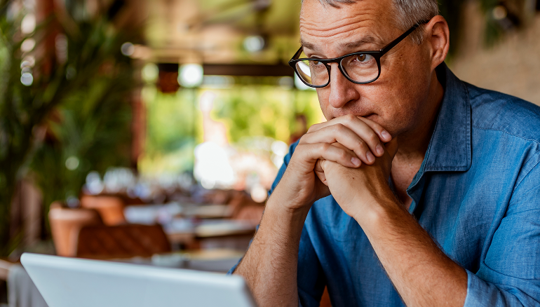 stressed-man-sitting-at-table-with-laptop